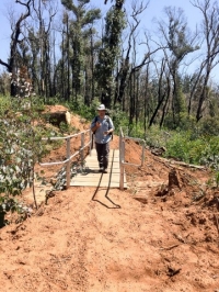 A new footbridge is built across a small creek on the new trail section.