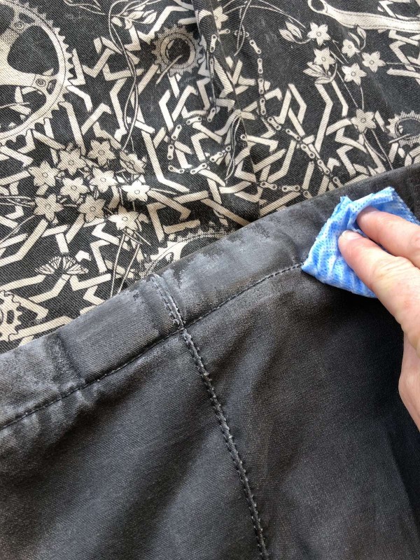 Applying liberal amount of wax to heated canvas